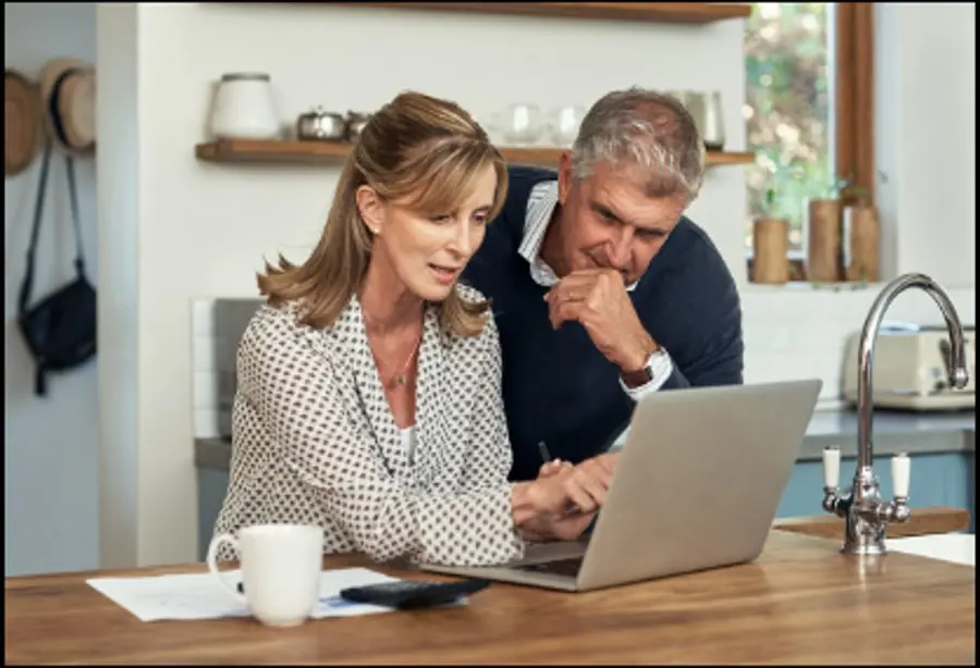 Senior couple reviewing plans on a laptop, representing proactive home care planning